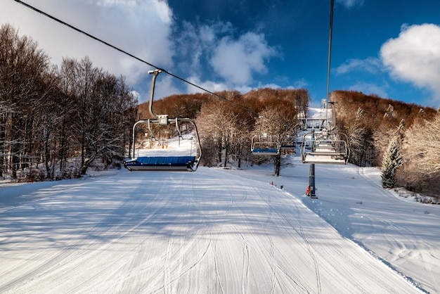 Sedie vuote alla stazione della sedia skilift presso il resort Snowland Valca nella stagione invernale
