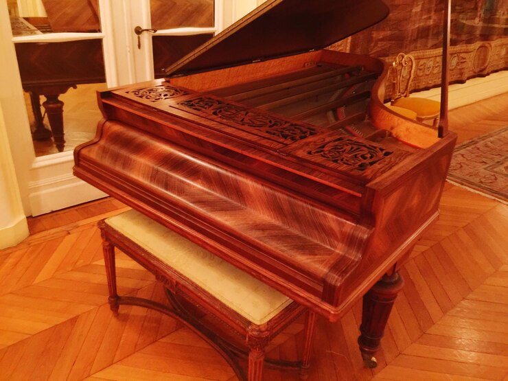 Foto sedile accanto al pianoforte sul pavimento di legno