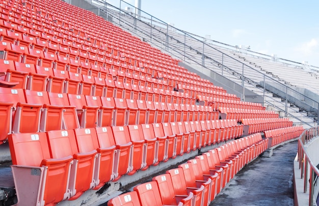 Sedili arancioni vuoti allo stadioRighe di posti su uno stadio di calcio