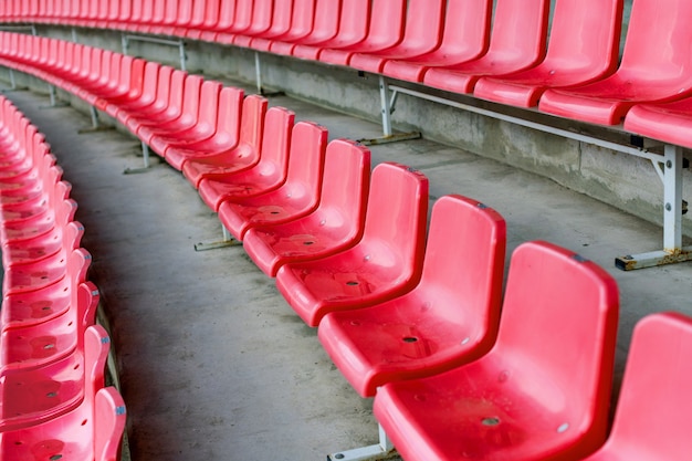 Sedili rossi dello stadio dopo la pioggia. Tribuna di calcio, calcio o stadio di baseball senza tifosi.