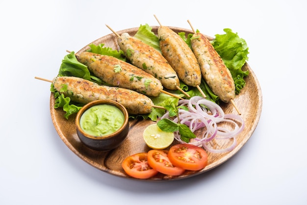 Seekh Kabab fatto con pollo tritato o keema di montone, servito con chutney verde e insalata