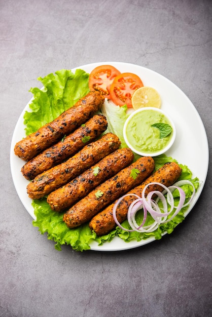 Seekh Kabab fatto con pollo tritato o keema di montone, servito con chutney verde e insalata