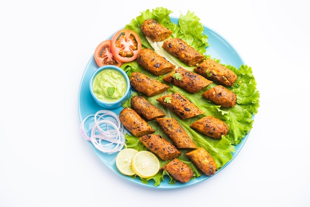 Seekh Kabab fatto con pollo tritato o keema di montone, servito con chutney verde e insalata