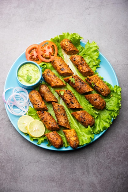 Seekh Kabab fatto con pollo tritato o keema di montone, servito con chutney verde e insalata