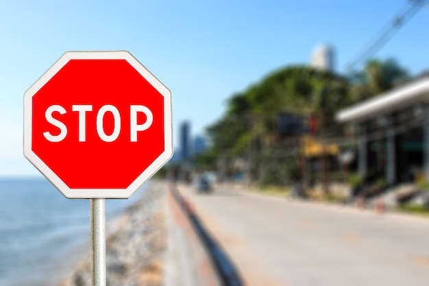 Segnale di stop per la strada della città vicino al mare