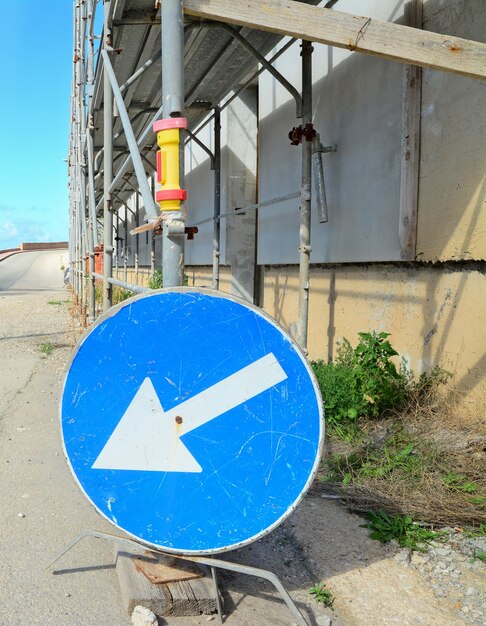 Segnale stradale blu da un'impalcatura metallica sul bordo della strada