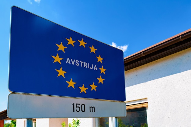 Segnale stradale di traffico moderno su blu con le stelle dell'UE - Avstrija, o simbolo di costruzione dell'Austria. Elemento di design. Concetto di informazioni stradali. Autostrada retrò. Struttura del bordo di trasporto. Cielo sullo sfondo