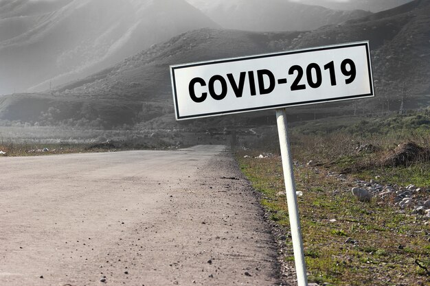 Segnale stradale e stradale con la parola - Covid-2019. Concetto di coronavirus di viaggio di pericolo.