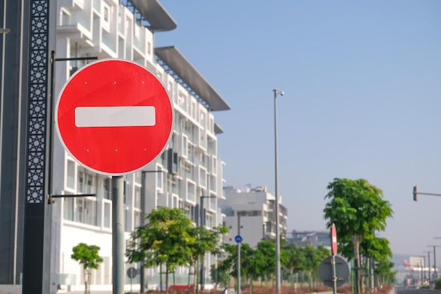 Segnale stradale vietato, ingresso vietato su una strada vuota sullo sfondo delle case cittadine