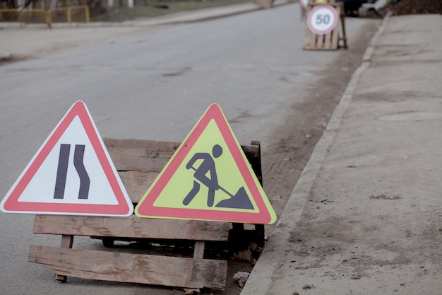 Segnali stradali, deviazione, riparazione della strada sul fondo della strada, foro di scavo camion ed escavatore