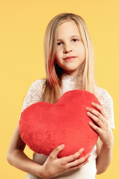 Segno d'amore La bella ragazza dà un grande cuore rosso del giocattolo