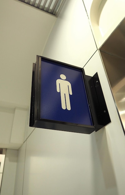 Segno della toilette reale o scheda di direzione del bagno e appeso al muro e colore blu e icona bianca.