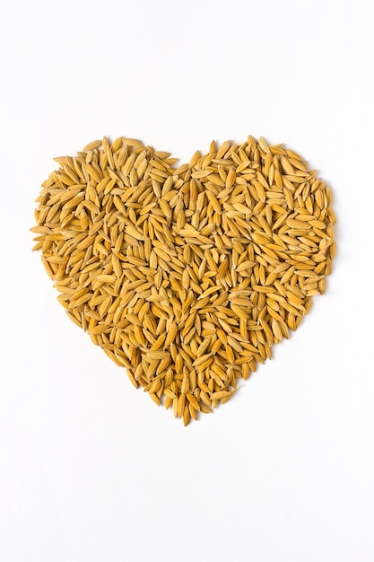segno di amante di riso. mucchio di chicchi di riso naturale a forma di cuore o amore