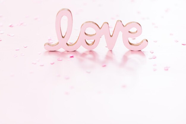 Segno di AMORE di San Valentino su sfondo rosa.