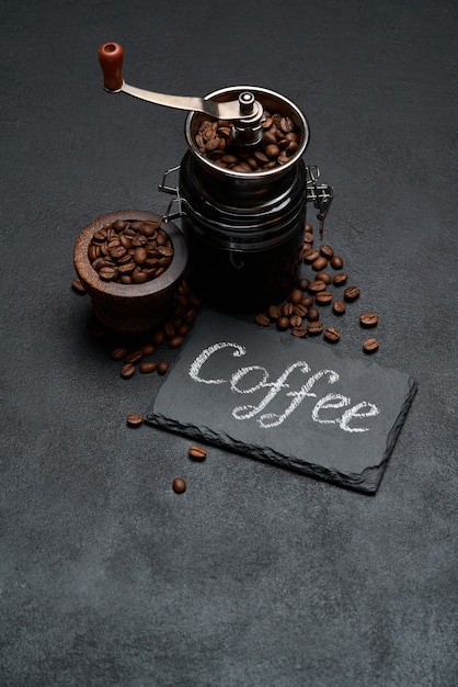 Segno di iscrizione manoscritta di caffè sulla lavagna e smerigliatrice a mano sul tavolo di cemento scuro