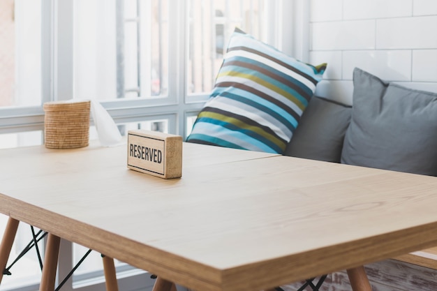 Segno di legno riservato sul piano d&#39;appoggio di legno con ed alla moda interno di un fondo accogliente del ristorante