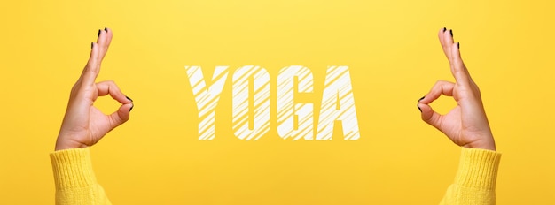 Segno di mano ok con iscrizione yoga su sfondo giallo alla moda, immagine panoramica