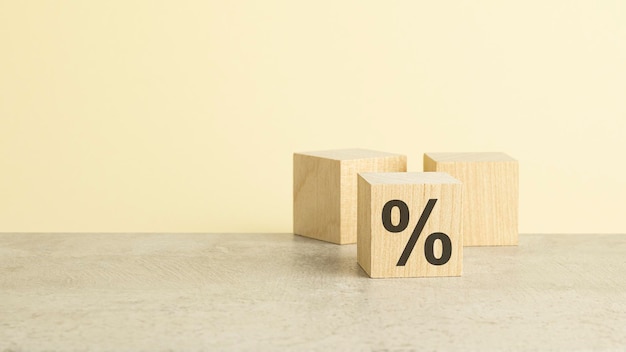 Segno di percentuale sul cubo di legno con il concetto dello spazio della copia di vendita e di sconto su fondo giallo