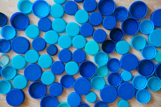 Segno di sedia a rotelle da tappi di plastica Sfondo di tappi di bottiglia di plastica blu Concetto di riciclaggio