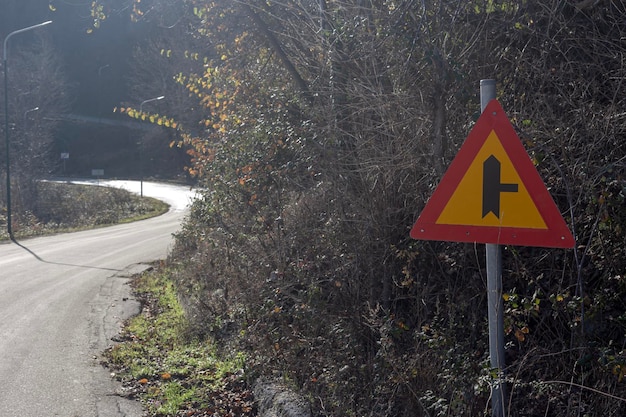 Segno di strada secondaria adiacente in un giorno d'autunno su una strada di montagna