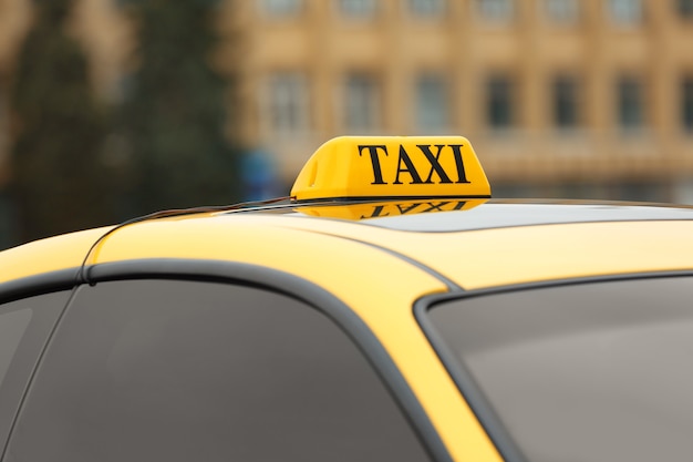 Segno di taxi giallo sul tetto dell'auto, primo piano