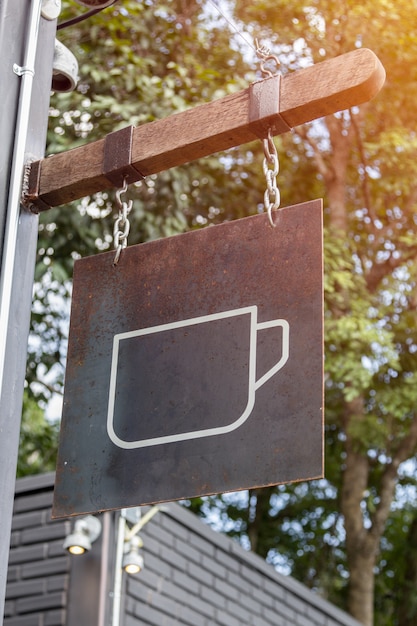 segno di tazza di caffè appeso sulla barra di legno