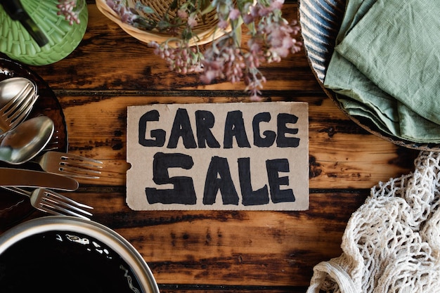 Segno di vendita di garage e oggetti usati sulla tavola di legno