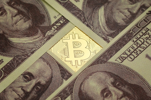 Segno e simbolo di criptovaluta sotto una pila di banconote in dollari. Idea per blockchain, il nuovo tipo di moneta nell'economia del mondo degli affari.