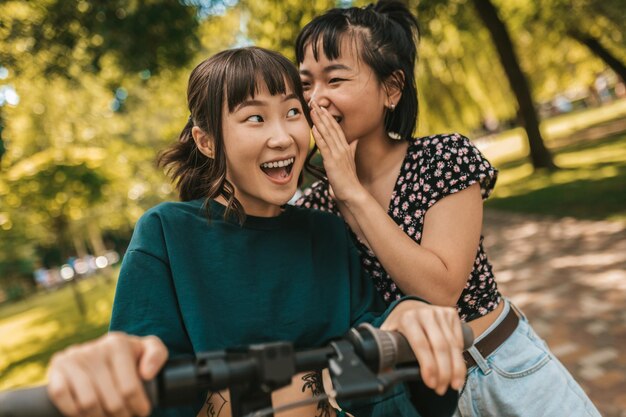 Segreti. Ragazze nel parco che condividono segreti e sembrano interessate