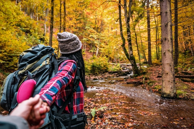 Seguimi con una donna turistica nella foresta autunnale