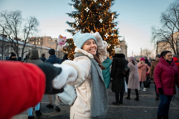 Seguimi donna di concetto che tira l'uomo all'albero di natale