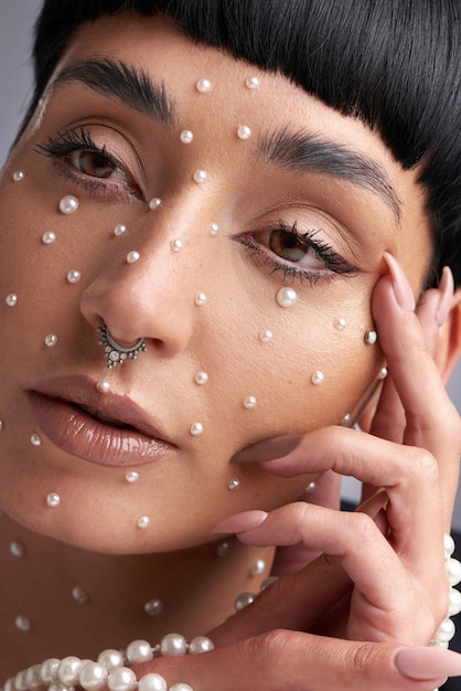 Sei unico, quindi fai tesoro della tua bellezza Foto in studio di una bella giovane donna con perle sul viso in posa su uno sfondo grigio