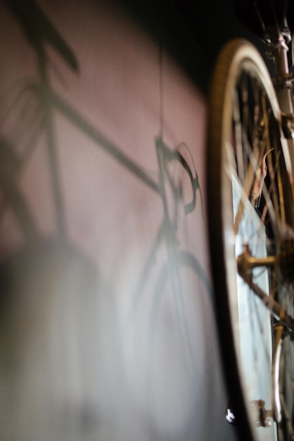 Selective focus shot di un'ombra di una vecchia bicicletta su una parete