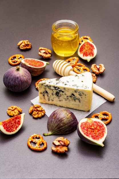 Selezione di antipasti al formaggio o set di snack al vino. Formaggio erborinato, fichi, miele, noci, salatini