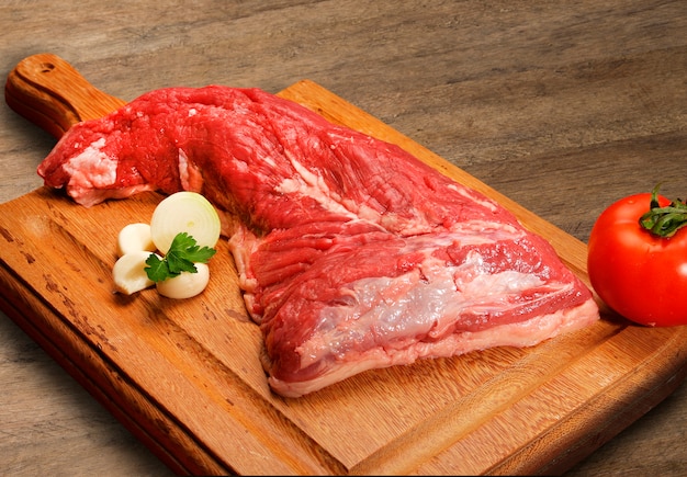 Selezione di carne cruda sul tagliere di legno.