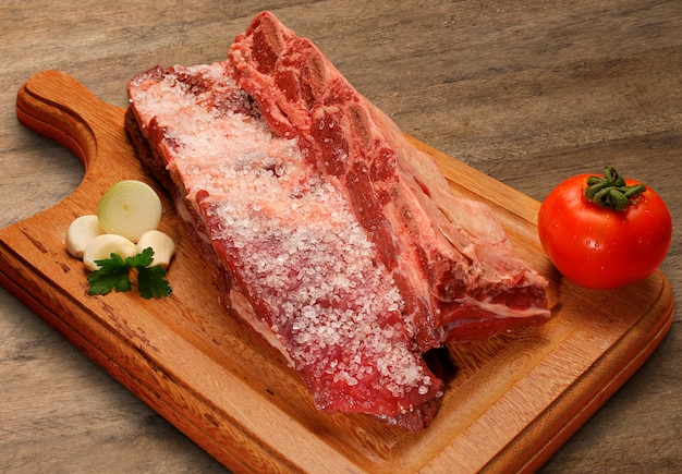 Selezione di carne cruda sul tagliere di legno.