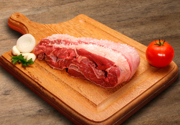 Selezione di carne cruda sul tagliere di legno.