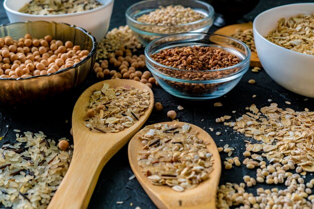 Selezione di cereali crudi crudi in grani in bulbi con ceci avena lenticchie riso grano saraceno