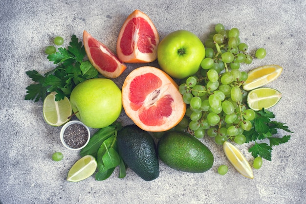 Selezione di verdure verdi e frutta su un dorso di cemento grigio