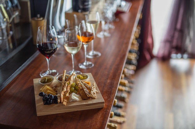 Selezione di vini e set di snack Varietà di olive al formaggio fette di baguette arrostite prosciutto uva