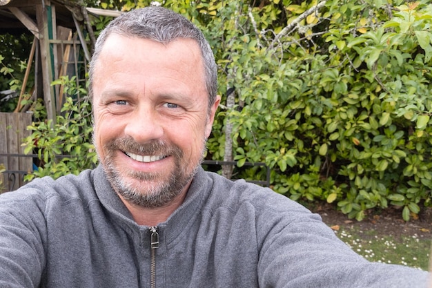 Selfie bel ragazzo uomo di mezza età all'aperto giardino casa parco ragazzo allegro che fa una foto