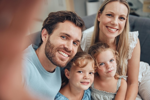 Selfie di famiglia e casa di una madre papà e bambine su un divano del soggiorno con amore e cura Genitori bambini e mamma con padre su un divano con un sorriso felice che si uniscono in un salotto