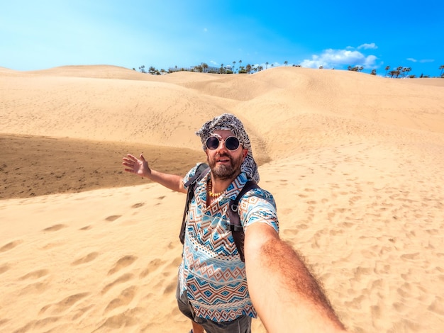 Selfie di un turista con occhiali da sole e turbante che si diverte nelle dune di Maspalomas Gran Canaria Isole Canarie