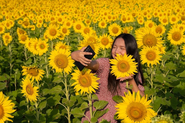 Selfie felice della ragazza con il bello girasole e cielo blu