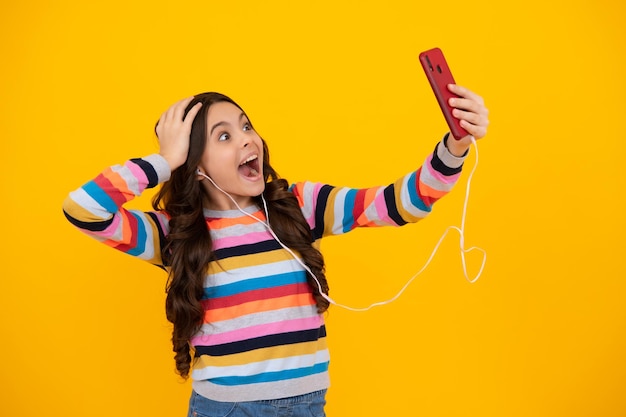 Selfie per bambini Ritratto di ragazza adolescente carina utilizzando il telefono cellulare in chat web digitando un messaggio sms Mobile