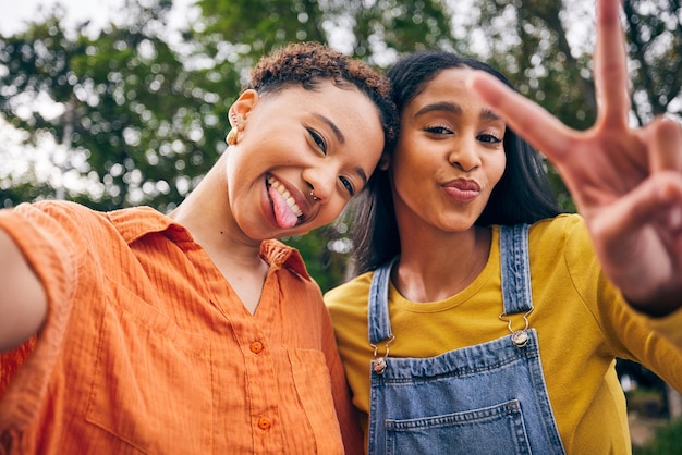 Selfie segno di pace e ritratto di donne nel parco per post online sui social media e foto del profilo Amicizia natura e persone di sesso femminile con segno a mano per foto per vacanze divertenti e relax all'aperto