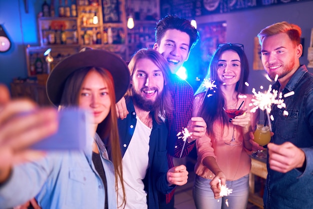 Selfie Time Giovane gruppo di amici che fanno festa in un locale notturno e brindano con bevande Giovani felici