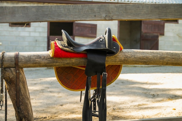 Sella di cavallo sulla ringhiera del recinto prima di cavalcare