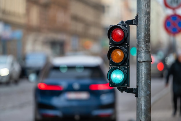 Semaforo sull'incrocio stradale con la bellissima città bokeh con le auto sullo sfondo