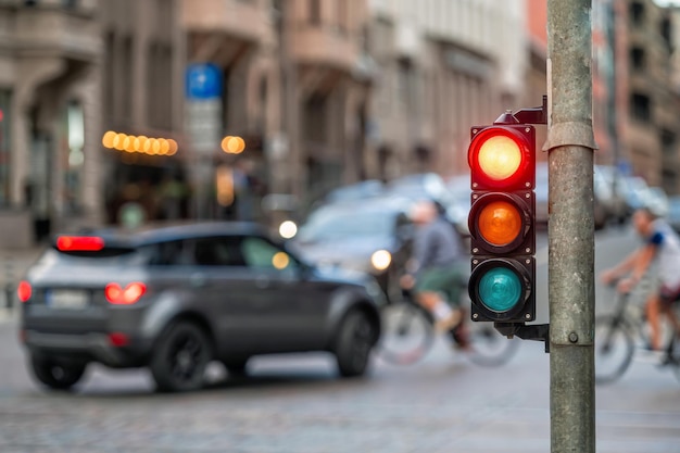 Semaforo sull'incrocio stradale con la bellissima città bokeh con le auto sullo sfondo